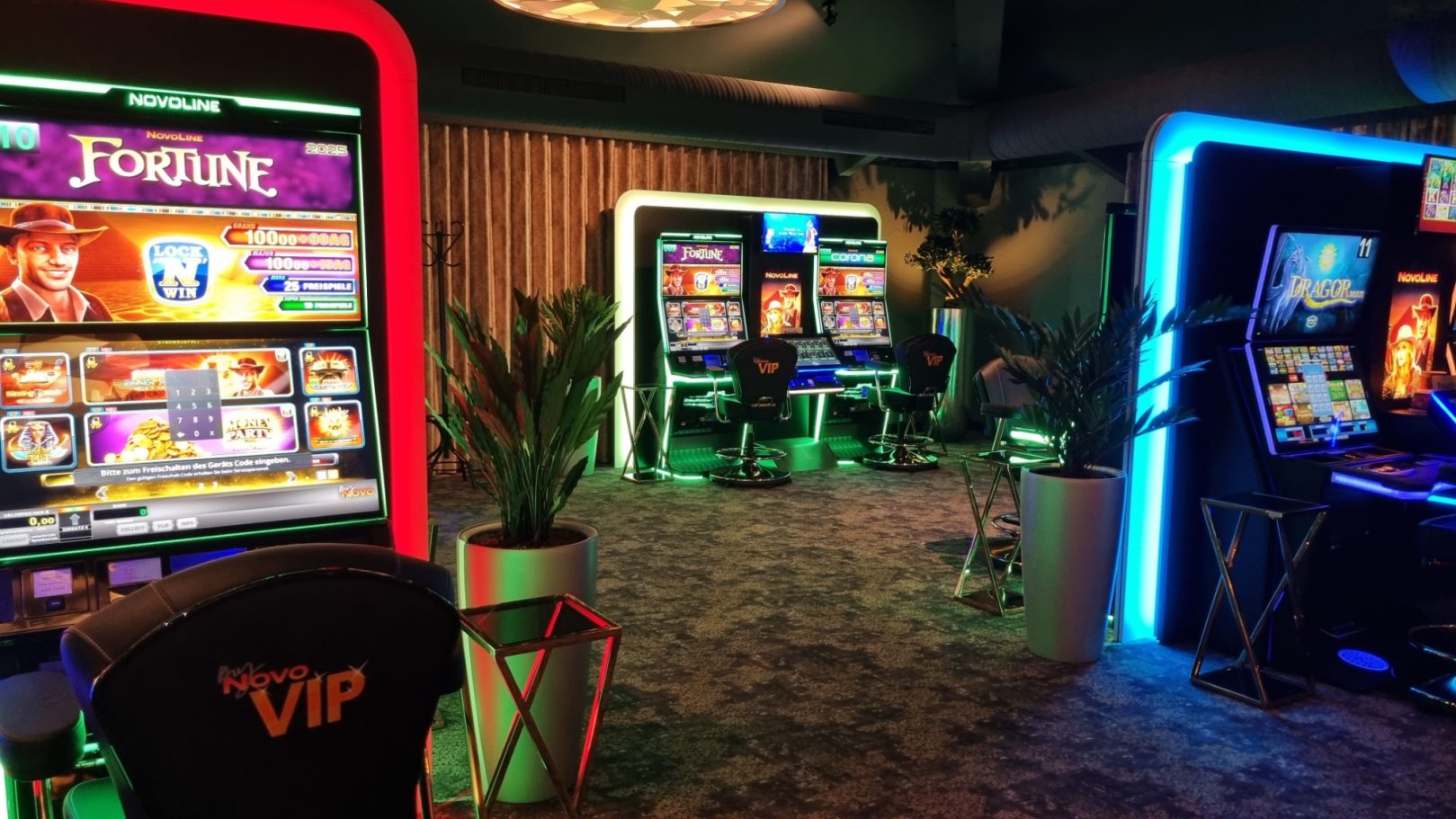 Spielautomaten in einem modernen Casino mit bunten Lichtern und Pflanzen.