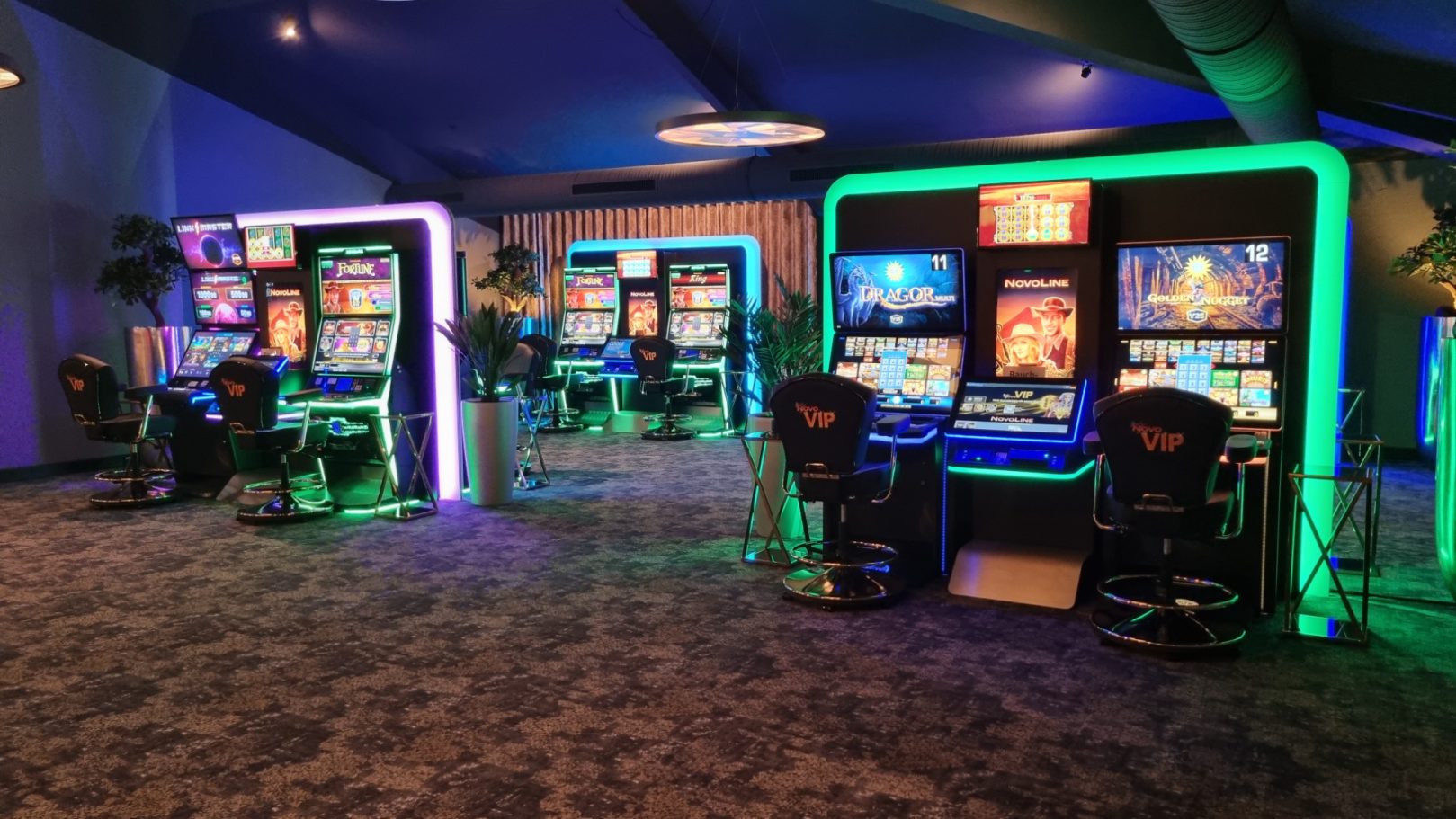 Spielhallenbereich mit Neonbeleuchtung und mehreren Spielautomaten.