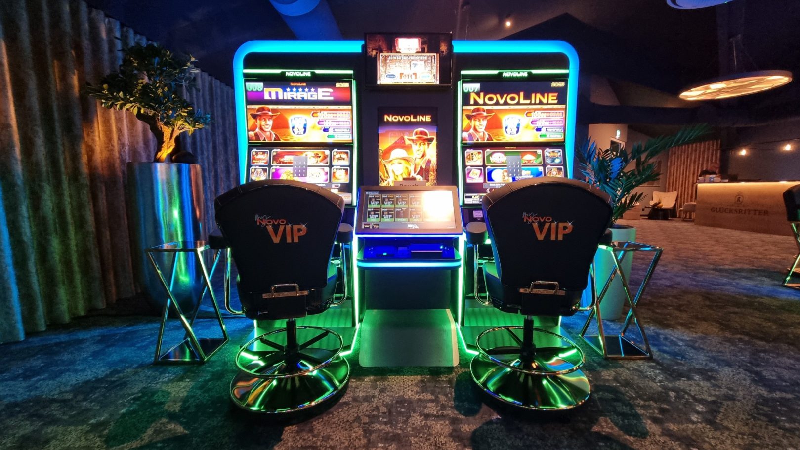 Zwei Spielautomaten mit bunten Bildschirmen in einem modernen Casino-Ambiente.